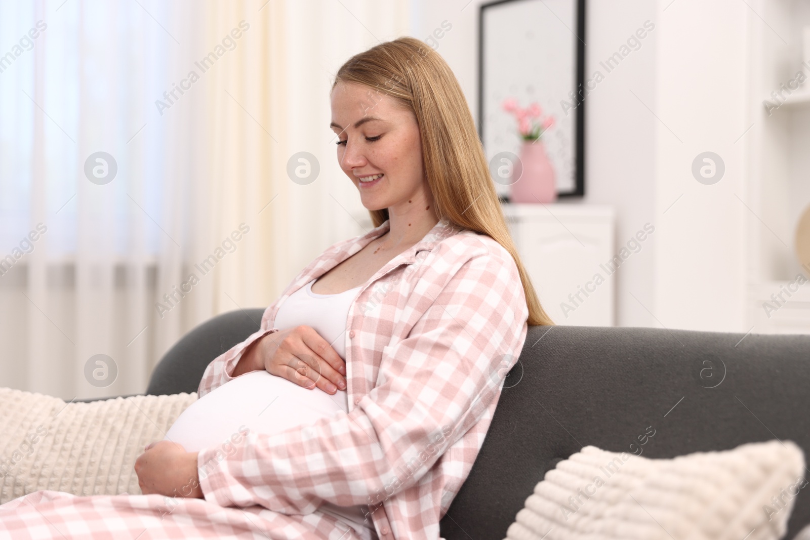 Beautiful pregnant woman on sofa at home Photo of Beautiful pregnant woman on sofa at home