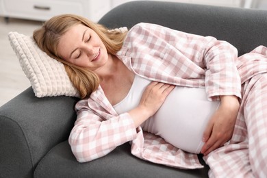 Photo of Beautiful pregnant woman lying on sofa at home