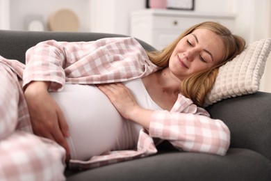 Photo of Beautiful pregnant woman lying on sofa at home
