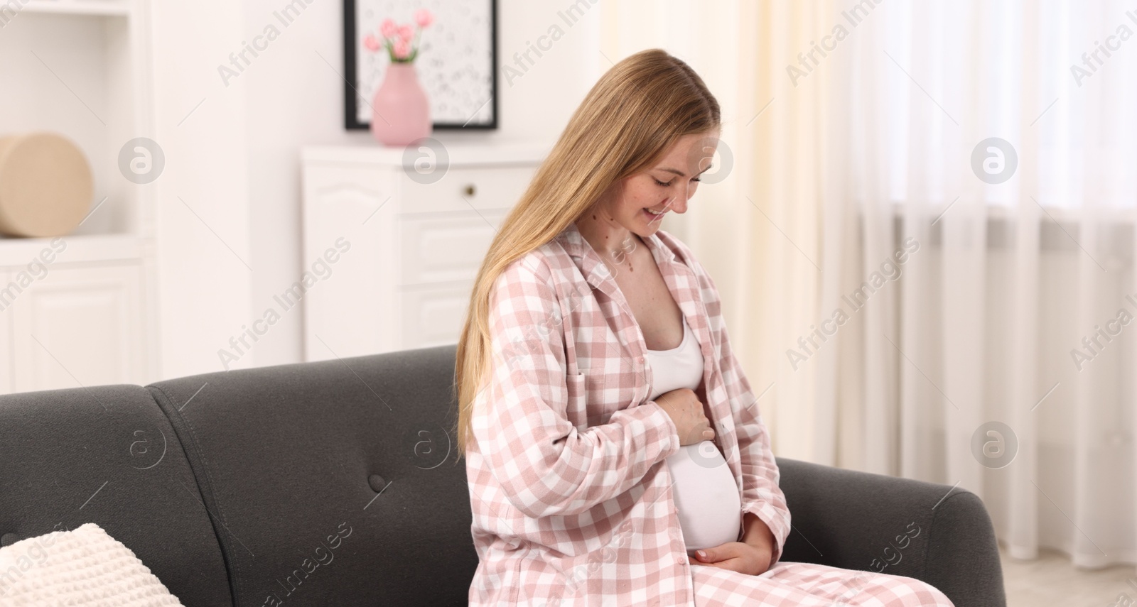 Beautiful pregnant woman on sofa at home Photo of Beautiful pregnant woman on sofa at home