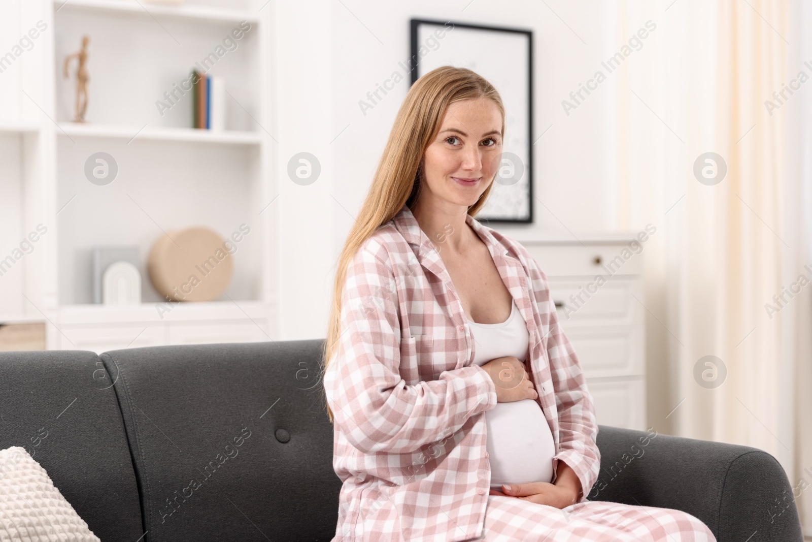 Beautiful pregnant woman on sofa at home Photo of Beautiful pregnant woman on sofa at home