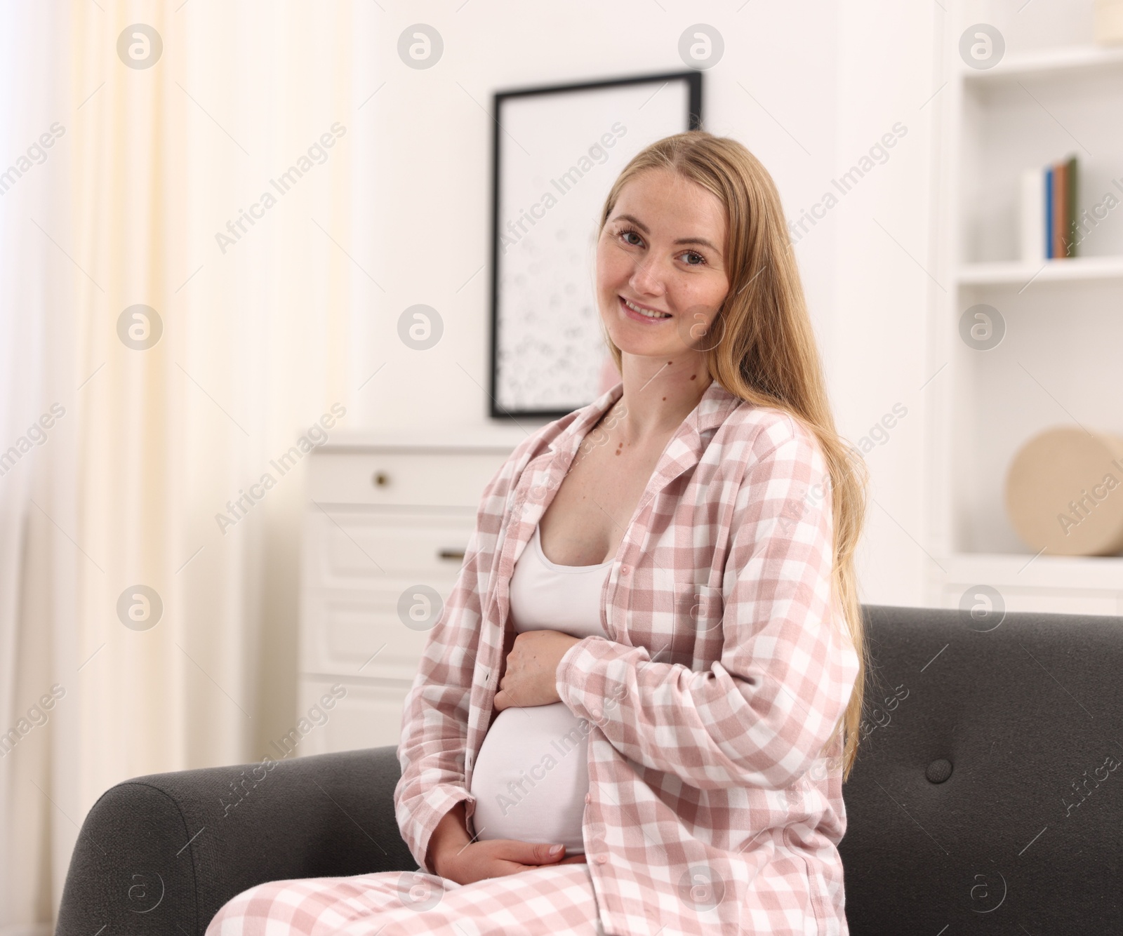Beautiful pregnant woman on sofa at home Photo of Beautiful pregnant woman on sofa at home