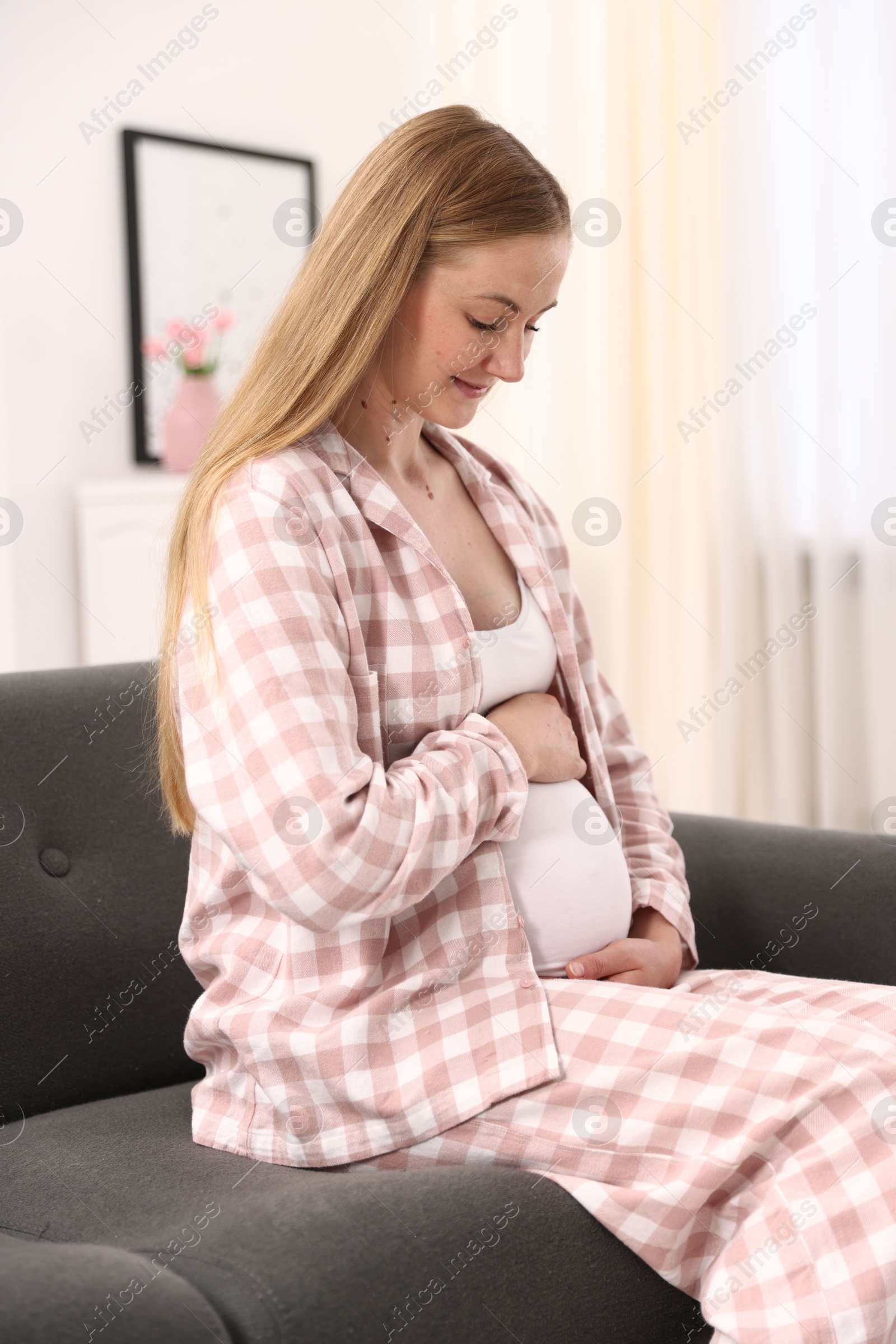 Beautiful pregnant woman on sofa at home Photo of Beautiful pregnant woman on sofa at home