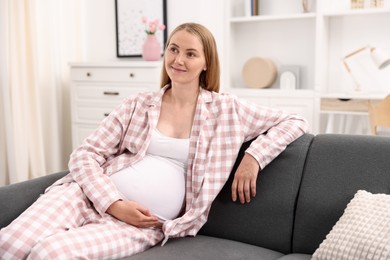 Photo of Beautiful pregnant woman on sofa at home