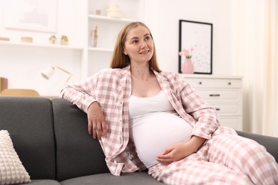 Photo of Beautiful pregnant woman on sofa at home