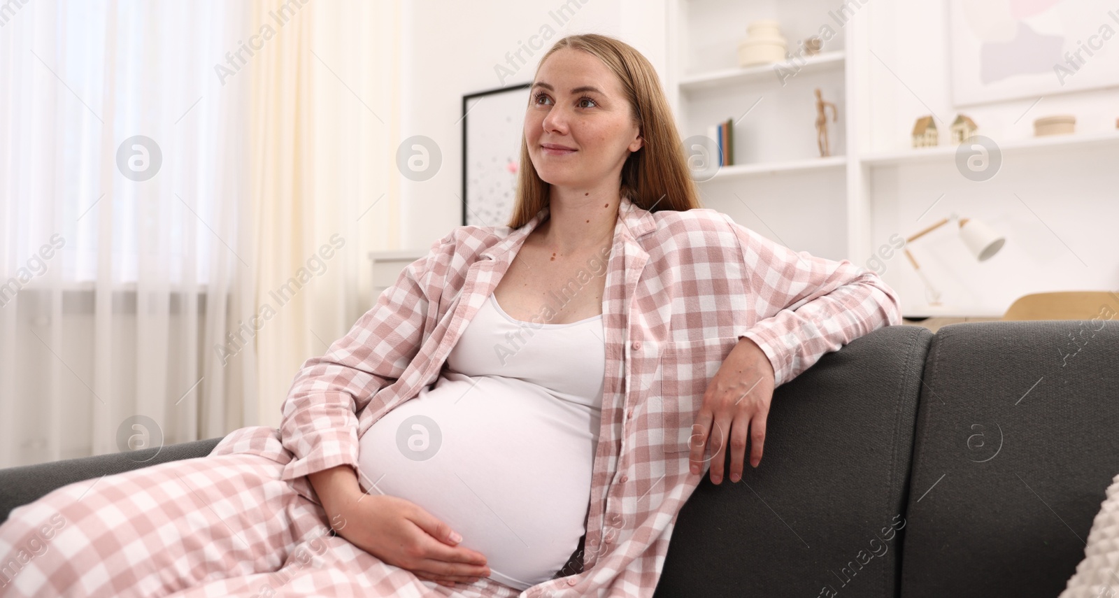 Beautiful pregnant woman on sofa at home Photo of Beautiful pregnant woman on sofa at home