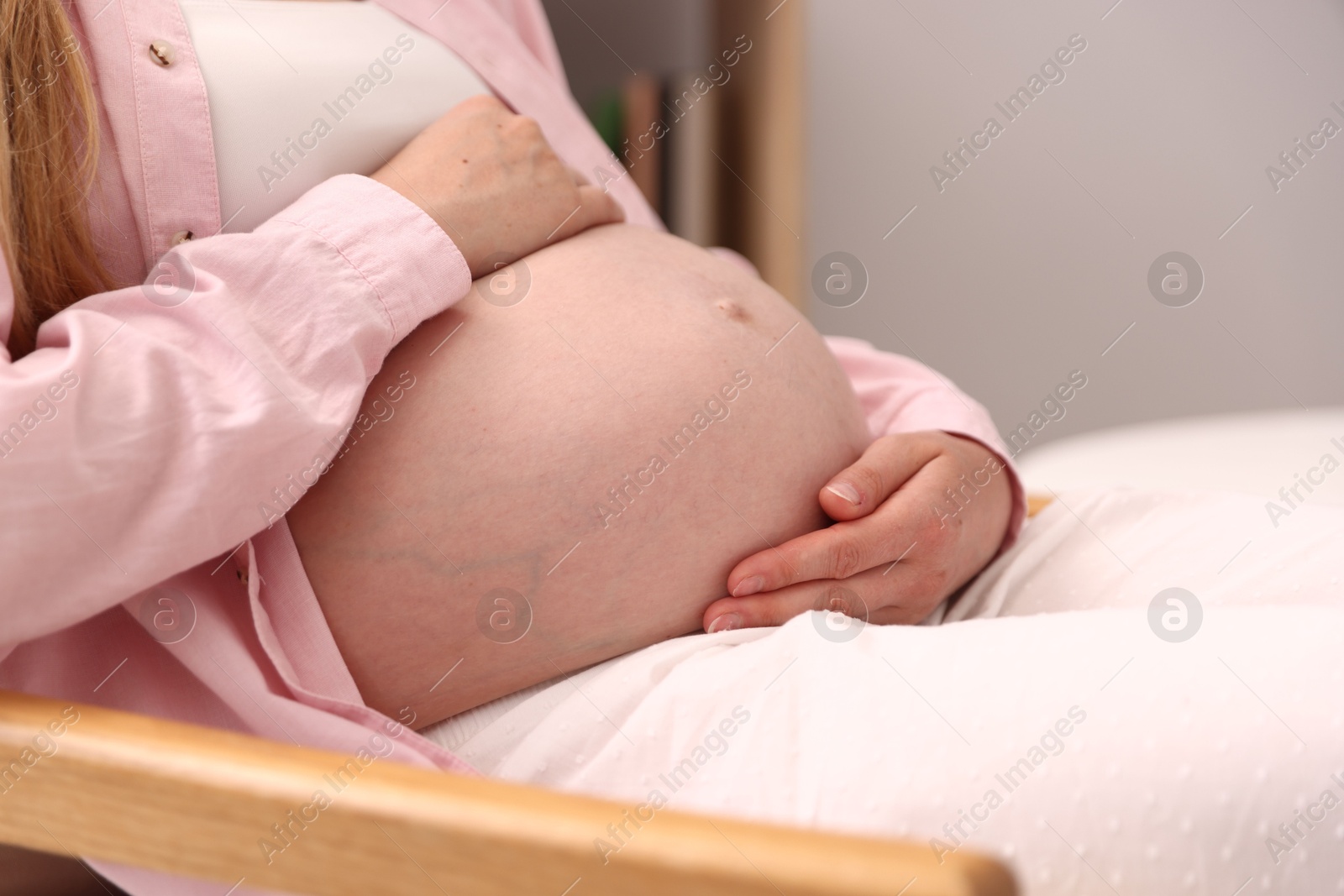 Beautiful pregnant woman in armchair at home, closeup Photo of Beautiful pregnant woman in armchair at home, closeup