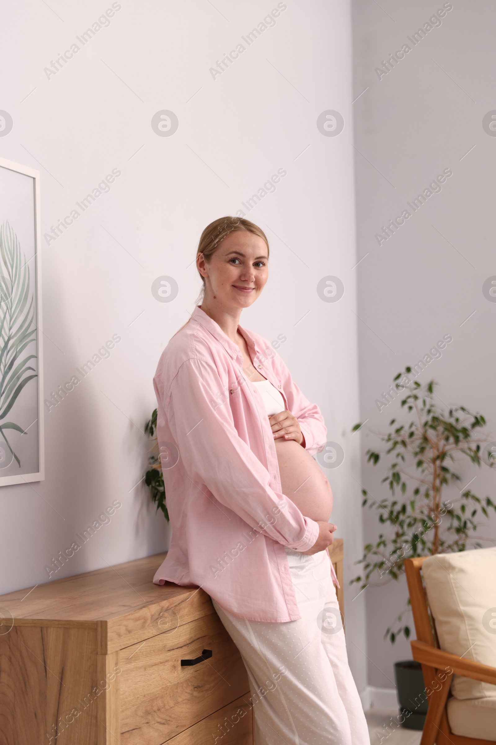 Beautiful pregnant woman touching her belly at home Photo of Beautiful pregnant woman touching her belly at home