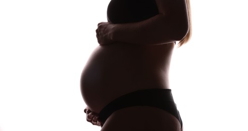 Photo of Silhouette of pregnant woman on white background, closeup