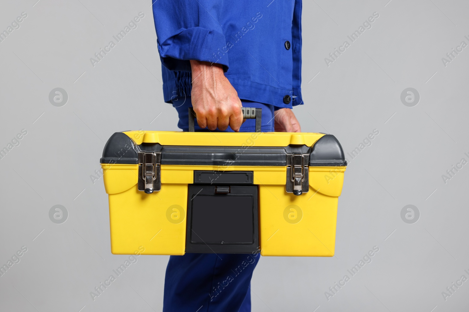 Professional repairman with tool box on grey background, closeup Photo of Professional repairman with tool box on grey background, closeup