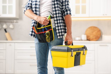 Photo of Professional repairman with tool box indoors, closeup