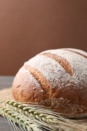 Photo of Fresh bread and green wheat spikes on table, closeup