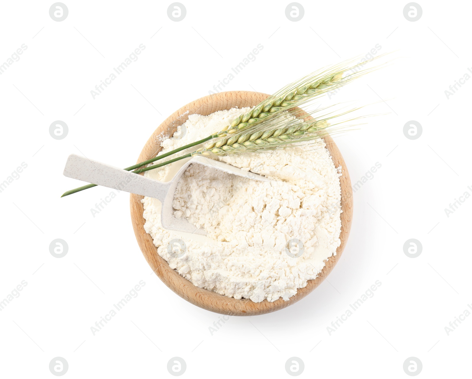 Photo of Flour in bowl and green wheat spikes isolated on white, top view
