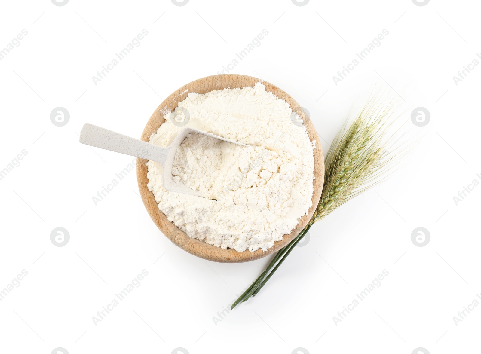 Photo of Flour in bowl and green wheat spikes isolated on white, top view