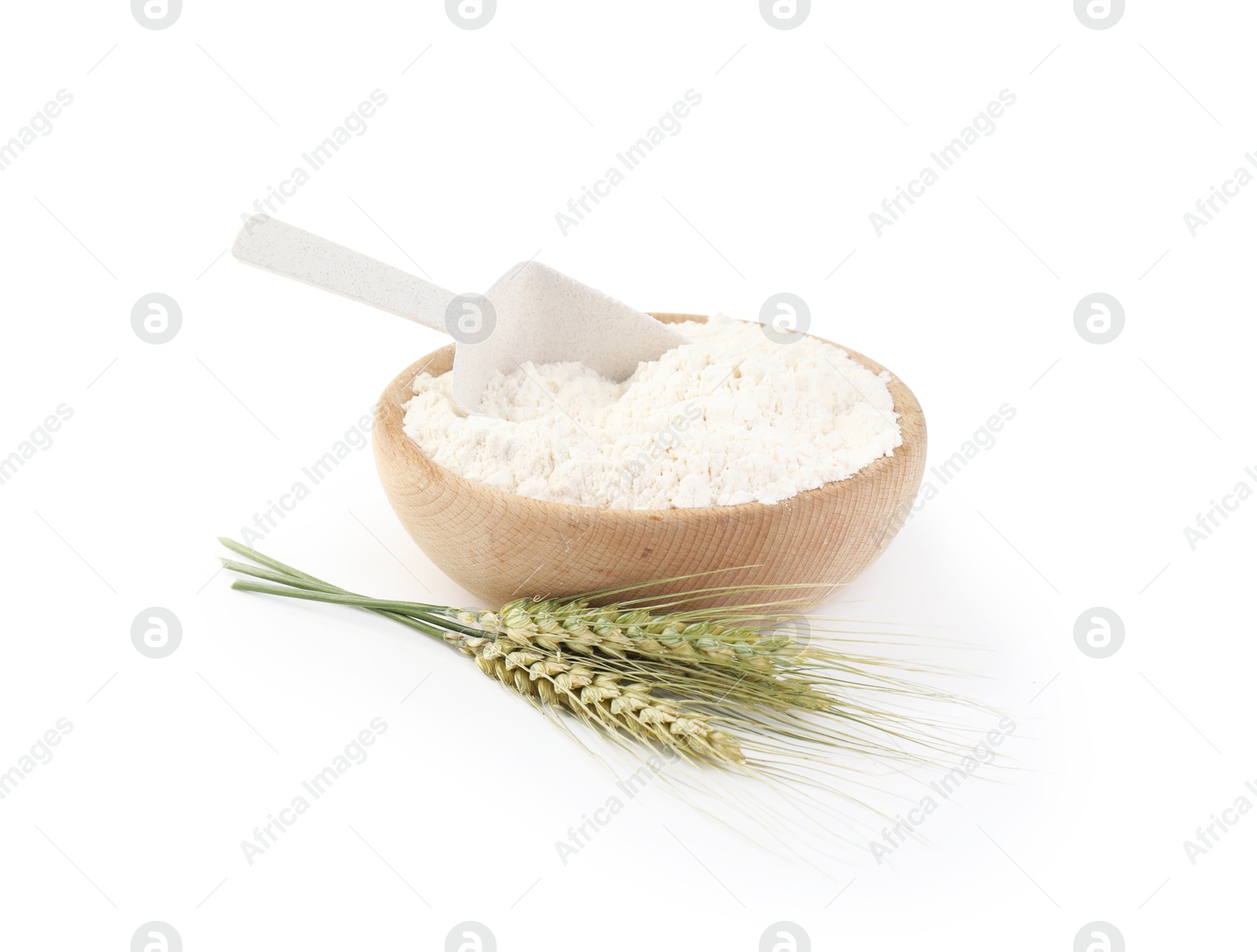 Photo of Flour in bowl and green wheat spikes isolated on white