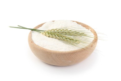 Photo of Flour in bowl and green wheat spikes isolated on white