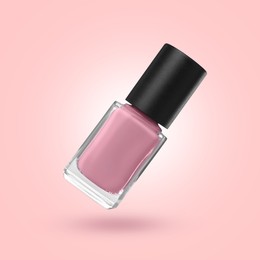 Image of Nail polish in air against pink background