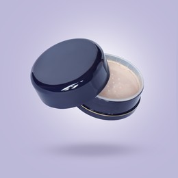Image of Loose face powder in air against lavender color background. Makeup cosmetics