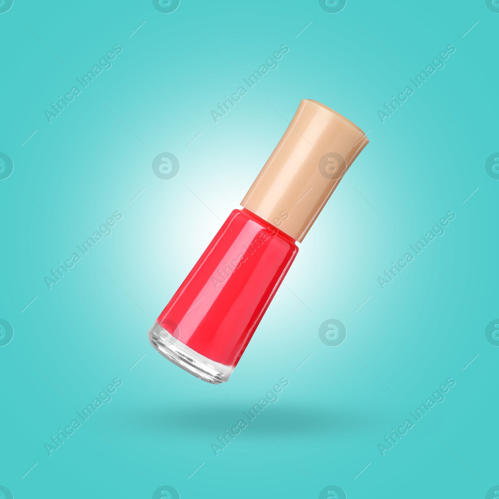 Image of Red nail polish in air against light blue background