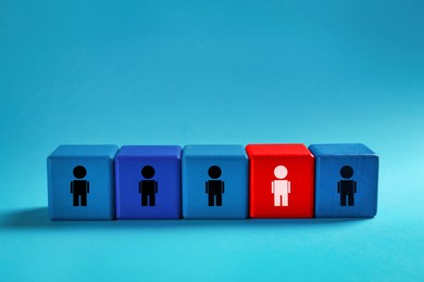 Image of Dismissal. Red cube with white human icon among others with black ones on light blue background
