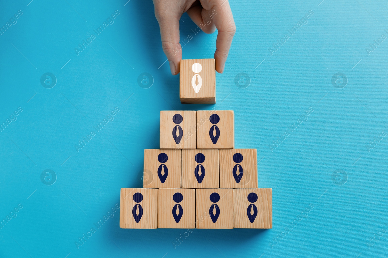 Dismissal. Woman taking cube with white human icon among others on light blue background, top view Image of Dismissal. Woman taking cube with white human icon among others on light blue background, top view