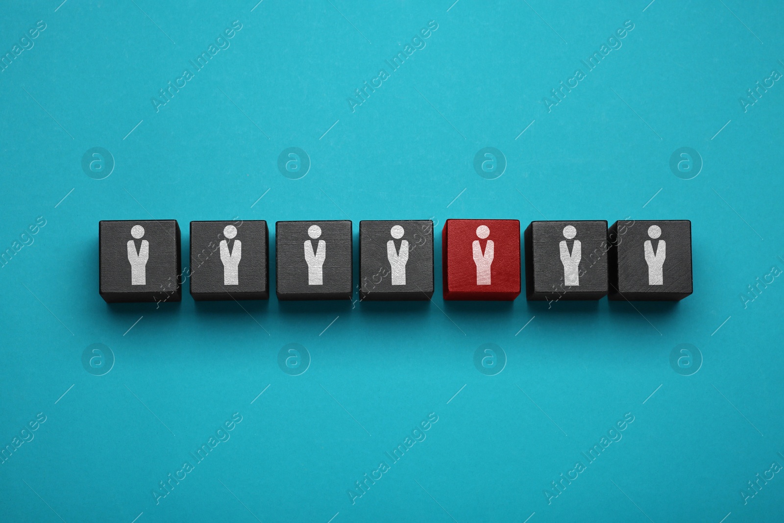 Image of Dismissal. Black cubes with human icons and one red on light blue background, top view
