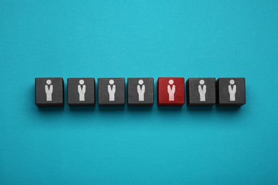 Image of Dismissal. Black cubes with human icons and one red on light blue background, top view