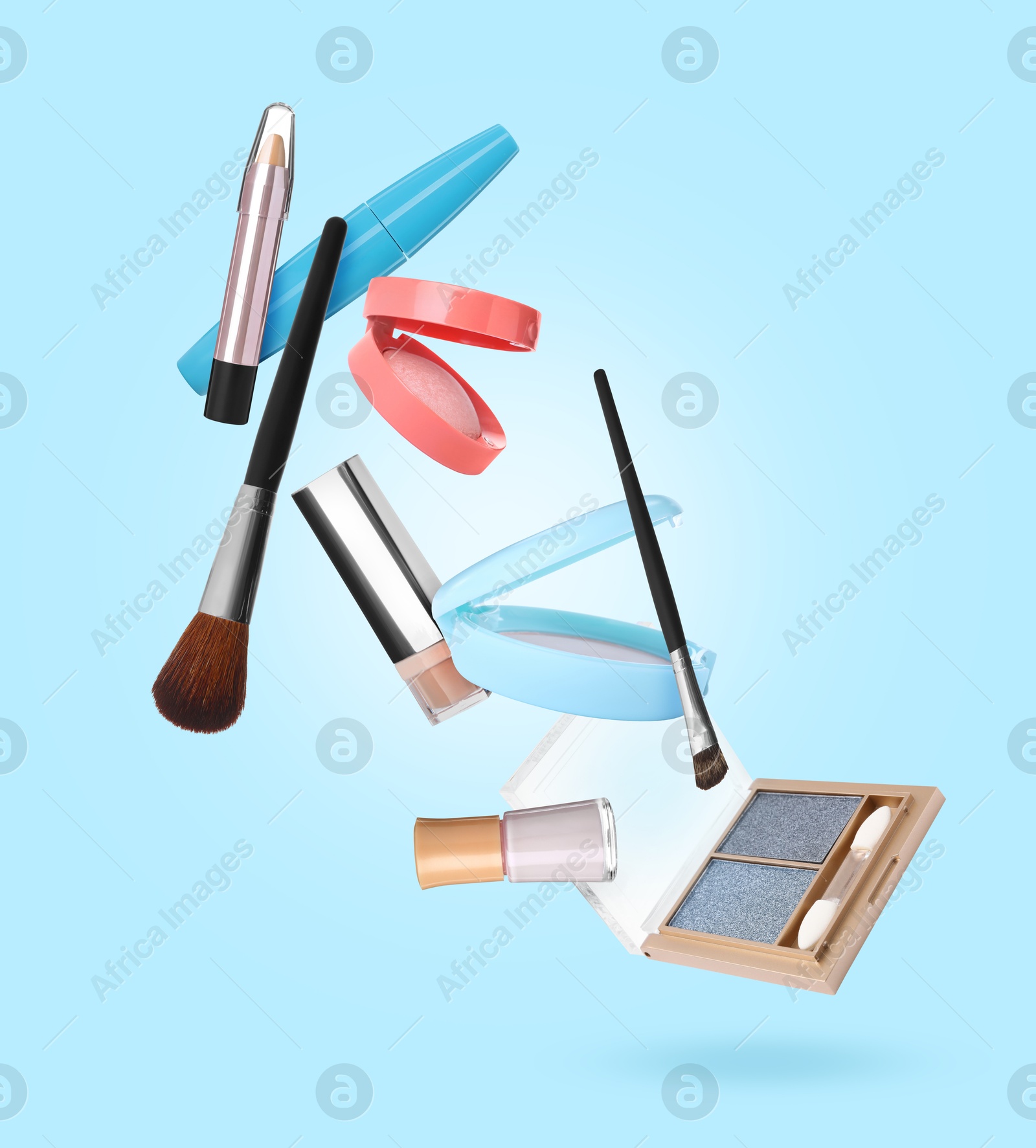 Different makeup products in air against light blue background Image of Different makeup products in air against light blue background