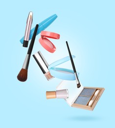 Image of Different makeup products in air against light blue background