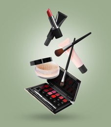 Image of Different makeup products in air against sage color background