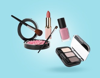 Image of Eyeshadow palette and other makeup products in air against light blue background
