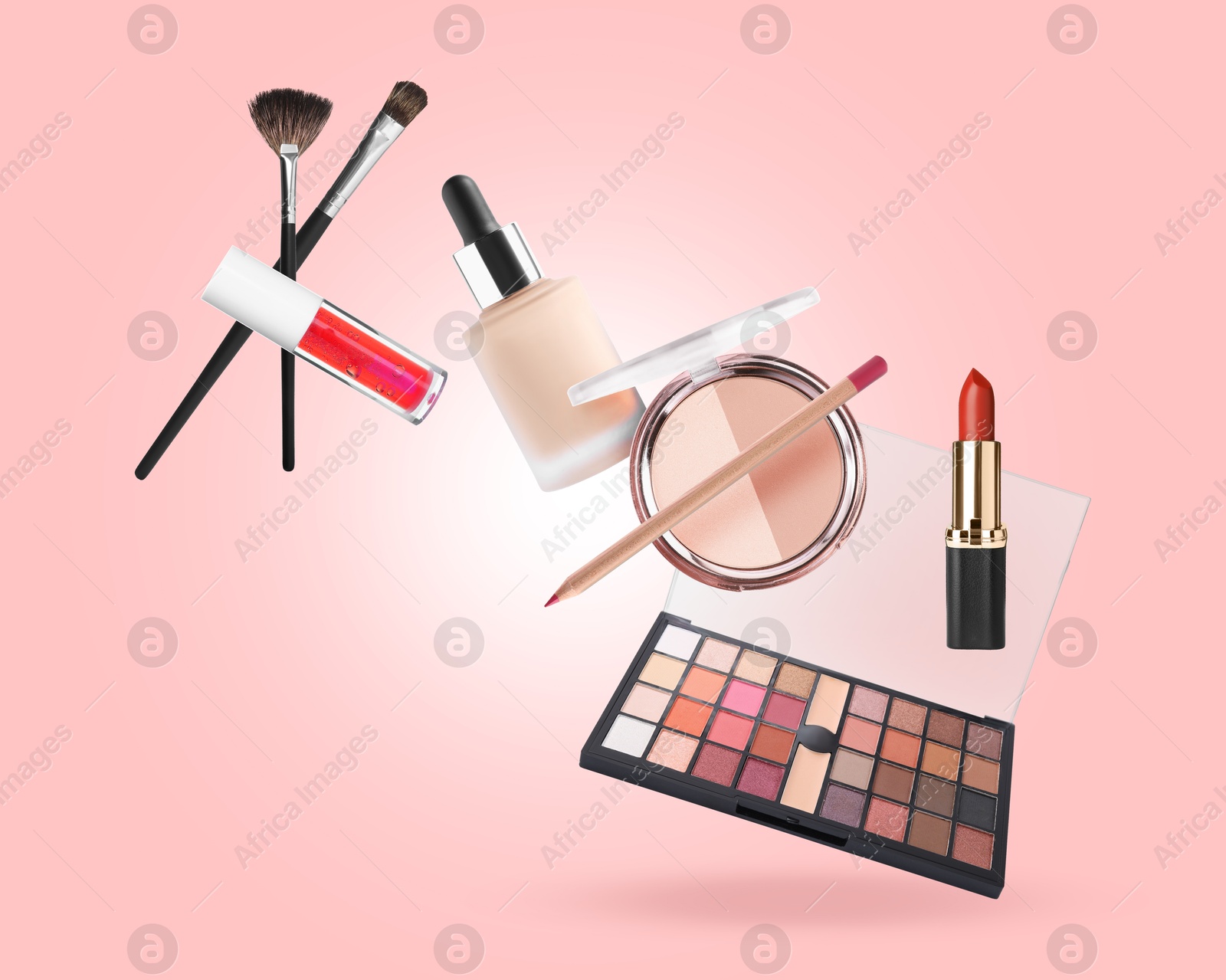 Image of Eyeshadow palette and other makeup products in air against pink background