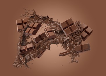 Image of Chocolate pieces and cacao drink splash on brown background