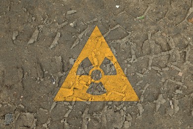 Image of Orange radioactive sign on ground with tire tracks, top view. Radiological pollution