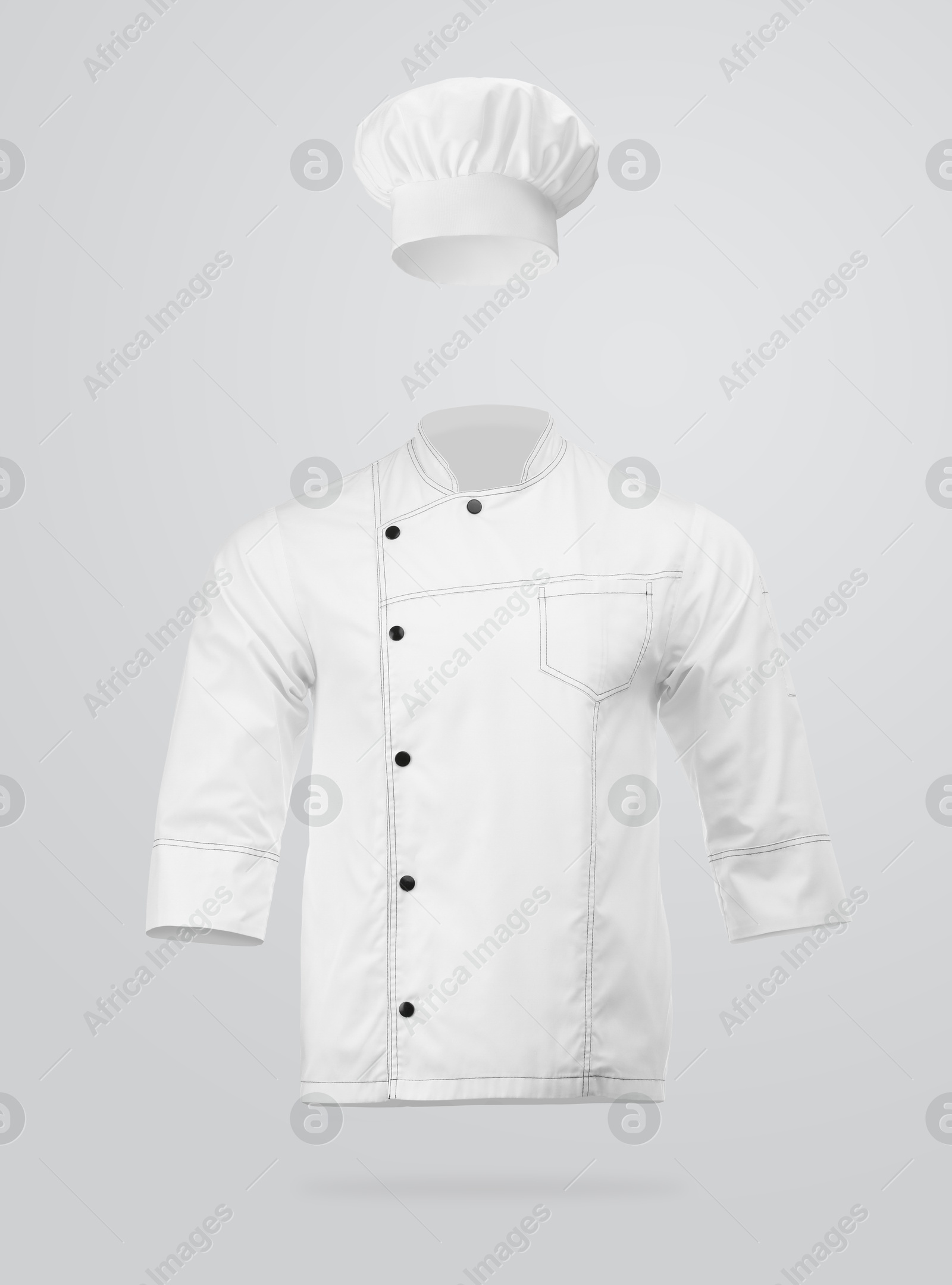 Image of Chef's uniform in air against light grey background. Toque and jacket