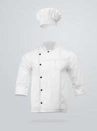 Image of Chef's uniform in air against light grey background. Toque and jacket