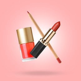 Image of Lipstick, nail polish and lip pencil in air against pink background. Makeup cosmetics