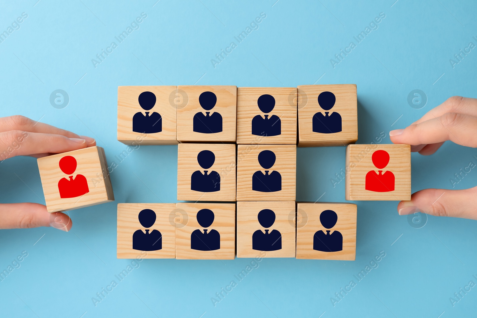 Image of Dismissal. Women taking cubes with red human icons among others on light blue background, top view