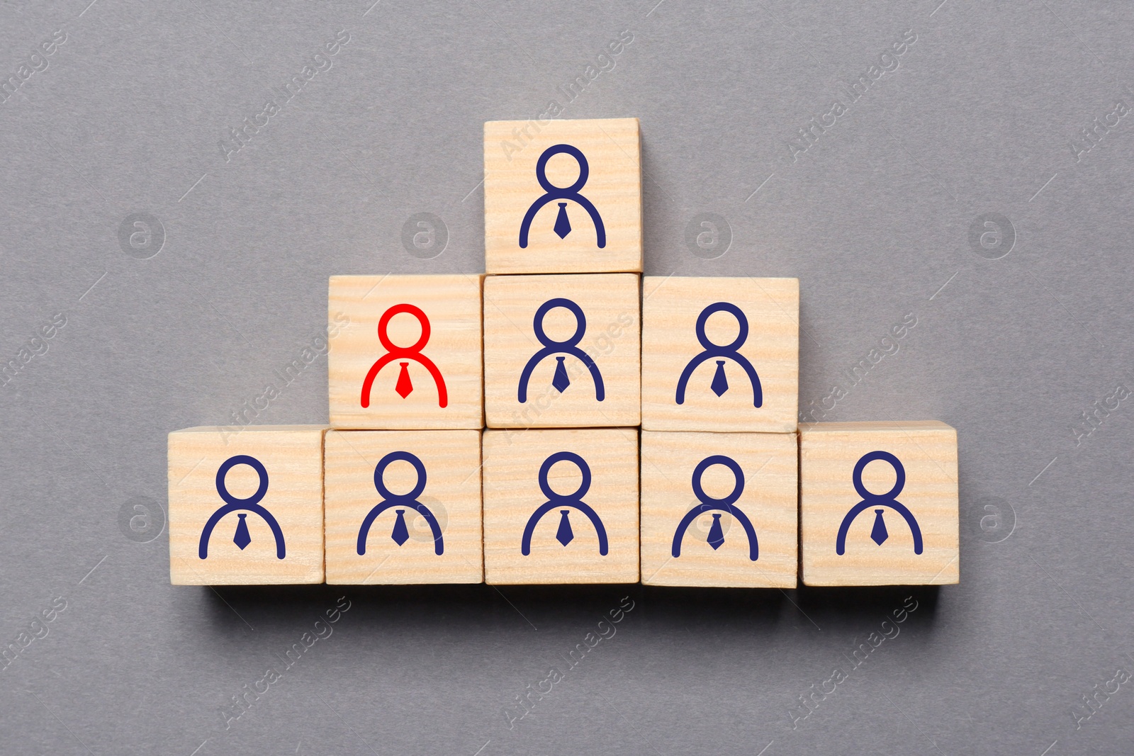 Image of Dismissal. Cube with red human icon among others with blue ones on grey background, top view