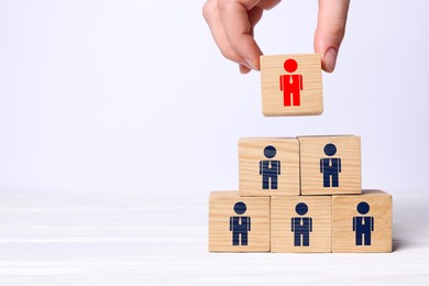 Image of Dismissal. Woman taking cube with red human icon among others with blue ones on white background, closeup