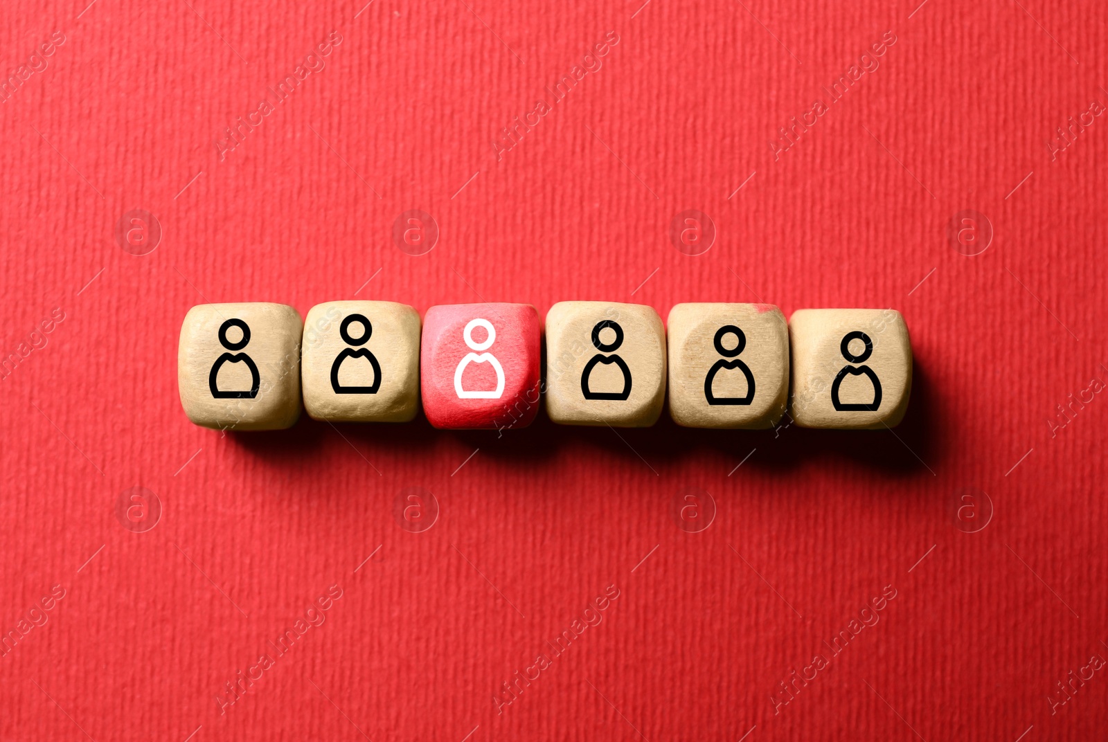 Image of Dismissal. Red cube with white human icon among others with black ones on red background, top view