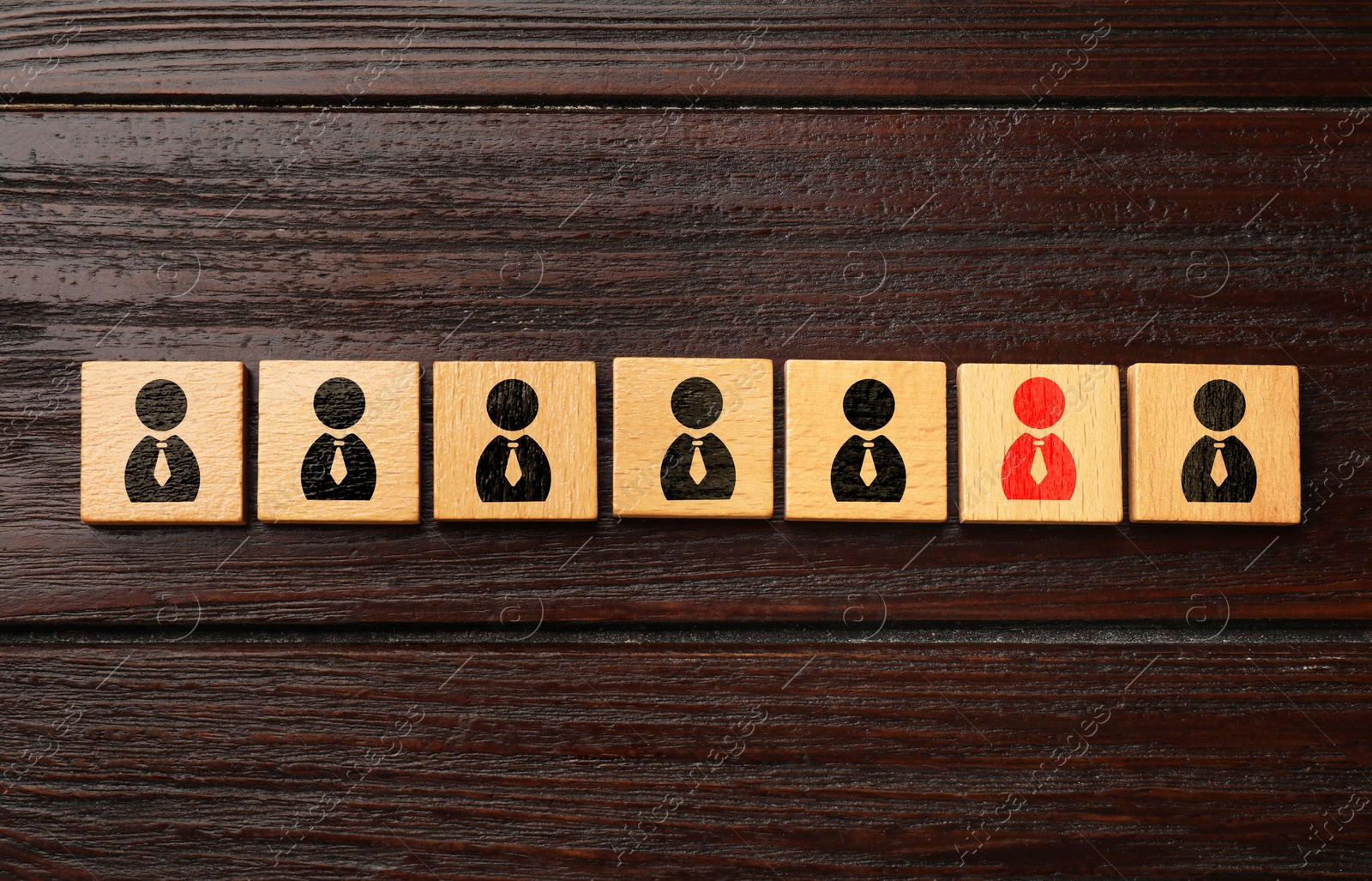 Image of Dismissal. Cube with red human icon among others with black ones on wooden background, top view