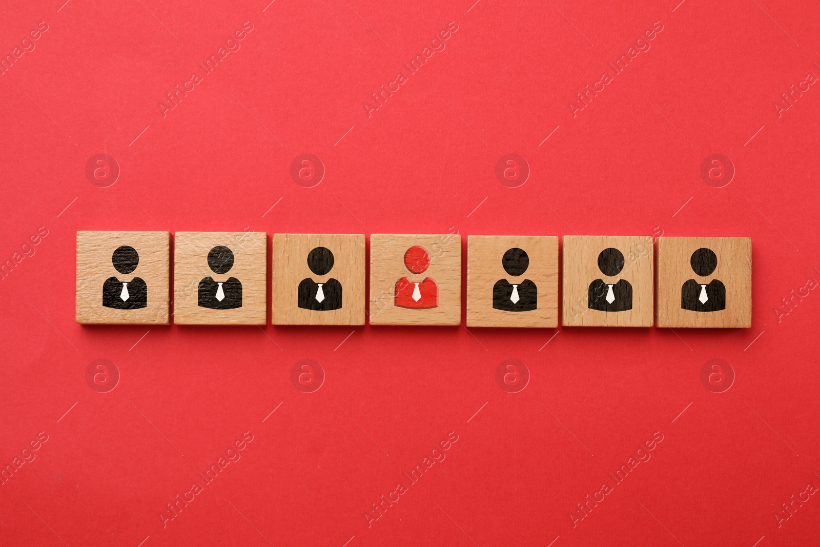 Image of Dismissal. Cube with red human icon among others with black ones on red background, top view