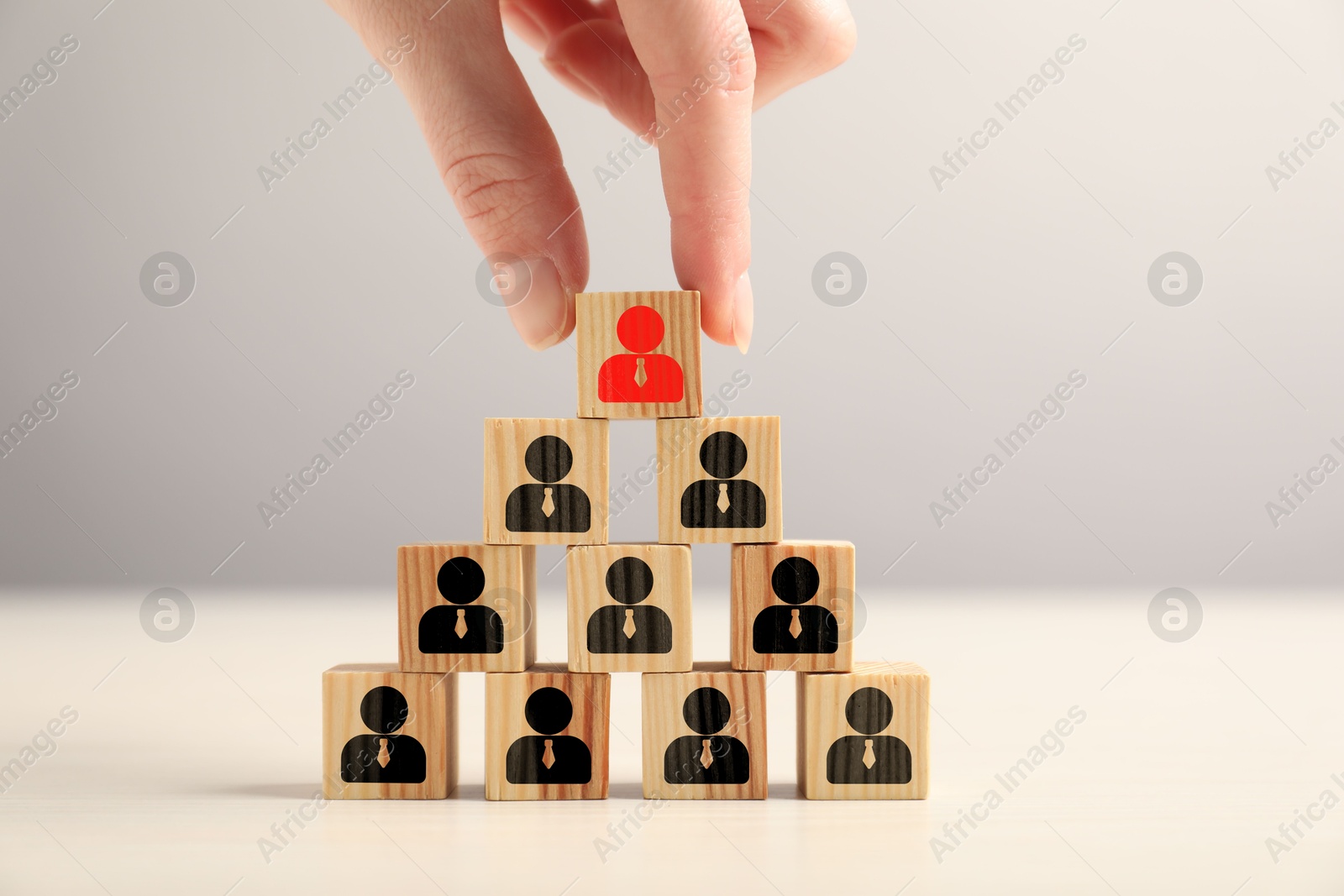 Dismissal. Woman taking cube with red human icon among others with black ones on table, closeup Image of Dismissal. Woman taking cube with red human icon among others with black ones on table, closeup