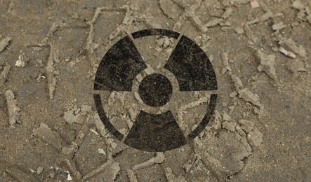 Image of Black radioactive sign on ground with tire tracks, closeup. Radiological pollution