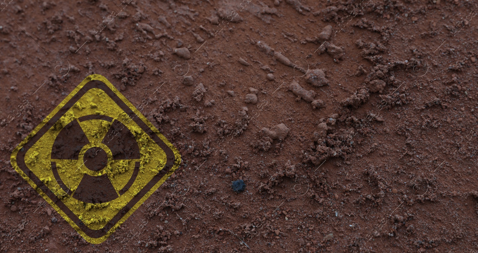 Image of Yellow radioactive sign on brown ground, top view. Radiological pollution