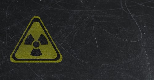 Image of Yellow radioactive sign on scratched black background, banner design. Radiological pollution