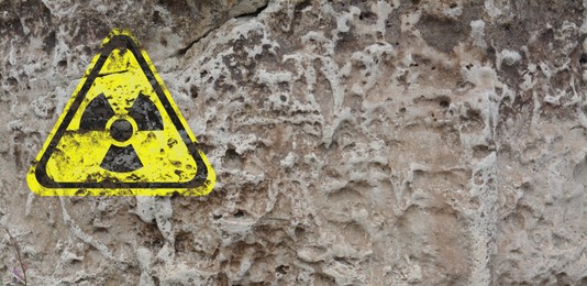 Image of Yellow radioactive sign on textured background, banner design. Radiological pollution
