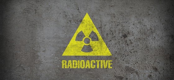 Image of Yellow radioactive sign on grey stone background, banner design. Radiological pollution