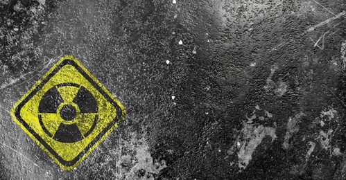 Image of Yellow radioactive sign on grey textured background, banner design. Radiological pollution
